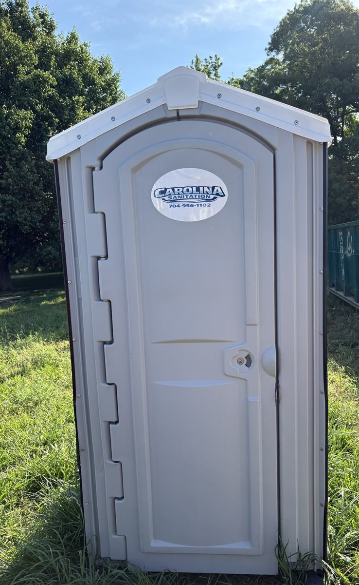 Carolina Sanitation white portable restroom unit set up outdoors